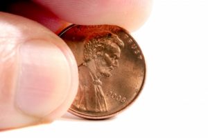 Fingers Holding A Penny Stock Photo